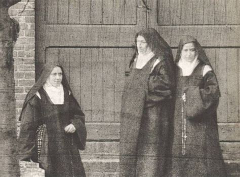 Three Women Dressed In Black Robes Standing Next To Each Other Near A