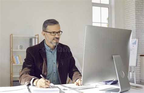 Mature Businessman Or Financial Accountant Working On Desktop Computer