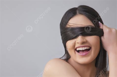 Cheerful Young Female Covering Eyes With Her Hair Over Colored