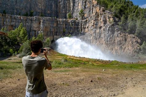 Young Man Photographing The Water Outlet Of A Dam Stock Image Image