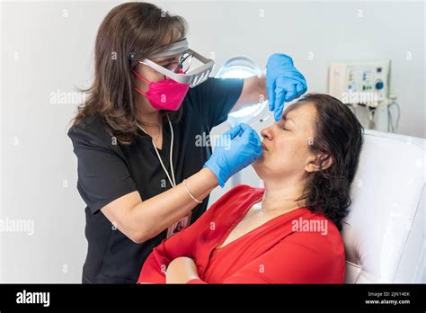 Female Dermatologist Doctor Applying Hyaluronic Acid Injection To A
