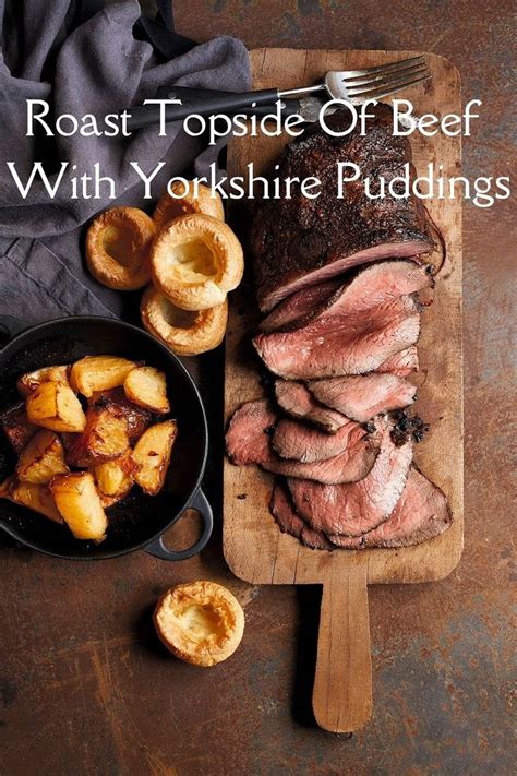 Roast Topside Of Beef With Yorkshire Puddings On A Wooden Cutting Board