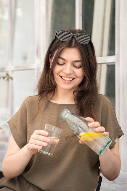 Premium Photo Attractive Young Woman Drinks Water With Lemon