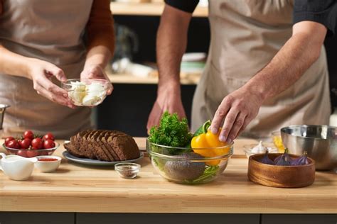 Premium Photo Close Up Of Couple In Aprons Taking Ingredients And