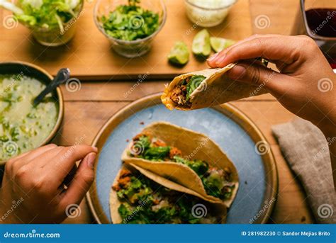 Woman S Hand Holding A Taco Of Marinated Meat Plate With Tacos Sauce