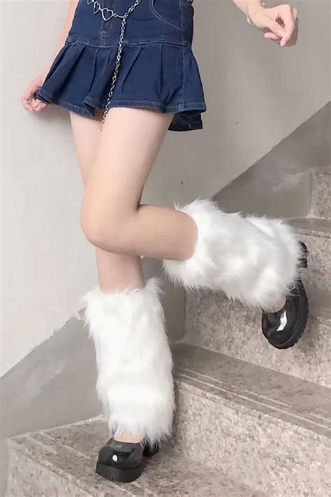 A Woman In Short Shorts And Furry Boots Posing On The Stairs With Her