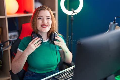 Young Redhead Woman Streamer Smiling Confident Sitting On Table At