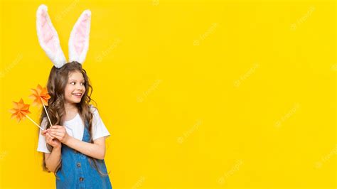 Premium Photo A Girl In A Dress With Bunny Ears On A Yellow Background