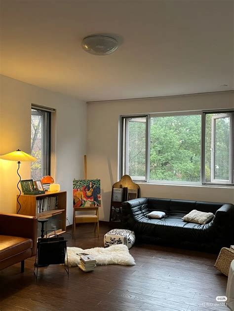 A Living Room Filled With Furniture Next To Two Large Windows On The