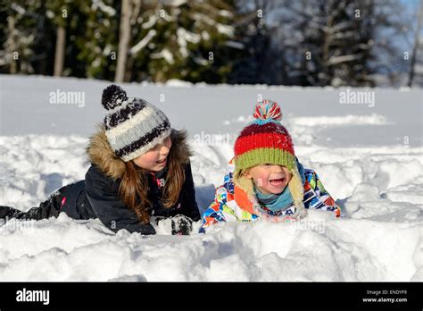 two children playing in the snow Stock Photo - Alamy