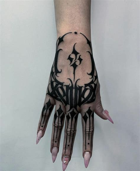 A Persons Hand With Black And White Tattoos On It Showing The Design