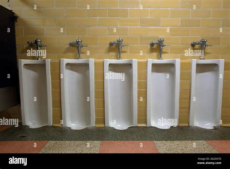 A bank of old school floor-mount urinals Stock Photo - Alamy