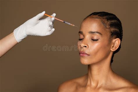 Skin Lifting Concept Headshot Of Black Middle Aged Woman Receiving Beauty Filler Injection In