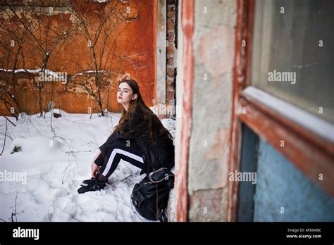 Fashionable Long Legs Brunette Model In Long Black Cloak Posed Outdoor At Winter Day Against Old