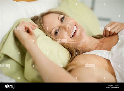 Portrait Of A Mature Woman Lying On The Bed And Smiling Stock Photo Alamy