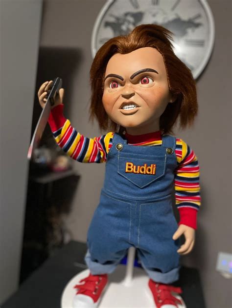 A Doll With Red Hair And Blue Overalls Is On Top Of A White Toilet