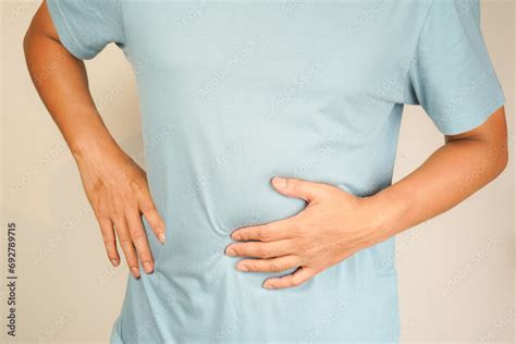 Male Having Stomach Ache Bending Over And Holding Hands On Stomach