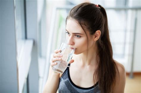 Premium Photo Smiling Pretty Woman Holds A Glass Of Water Leaning