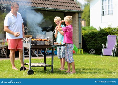 Father With Sons Grilling Meat In The Garden Stock Photo Image 44140525