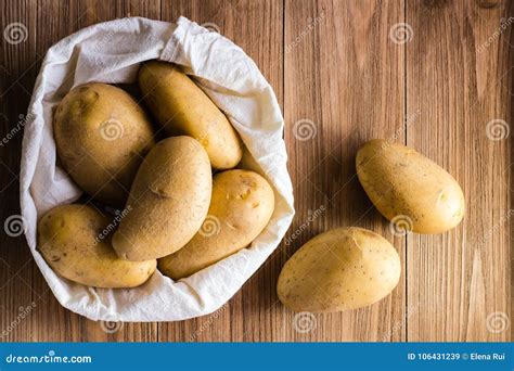 Patatas Sin Pelar Crudas En El Bolso Y En Una Tabla De Madera Imagen De