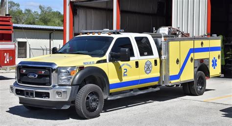 A Yellow And Blue Fire Truck Parked In Front Of A Building