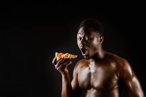 Premium Photo Black Handsome Naked Man Eats A Pizza