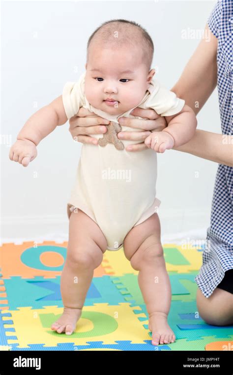 Portrait Of A Little Adorable Newborn Infant Baby Girl Standing Up With