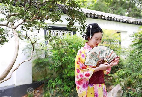 Traditional Asian Japanese Beautiful Geisha Woman Wears Kimono Hold A Fan On Hand In A Summer