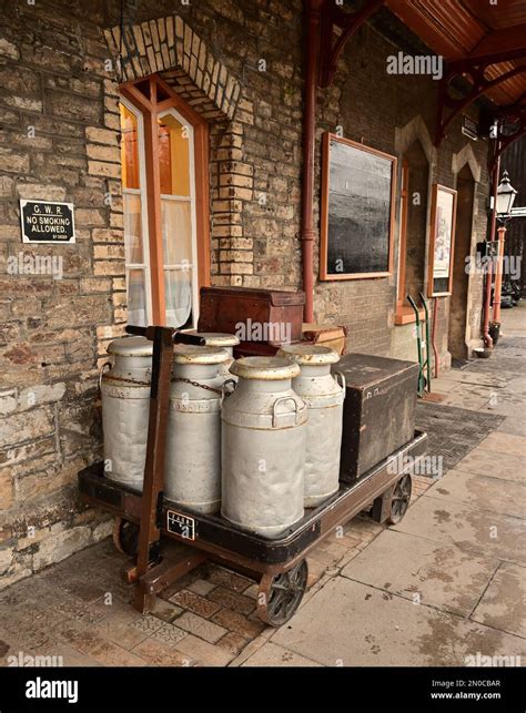 Old Fashioned Milk Churns And Luggage On A Platform Trolley At