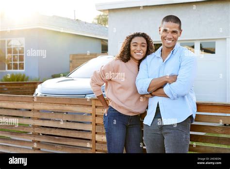 Portrait Of Smiling Heterosexual Couple Against House In Back Yard