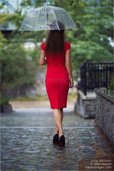 Photo Of Elegant Woman In Red Dress With Umbrella Walking Away In The