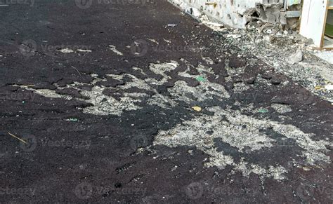 War in Ukraine. Funnel from the explosion in the asphalt. The trace ...