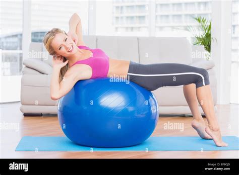 Slim Blonde Doing Sit Ups On Exercise Ball Smiling At Camera Stock Photo Alamy