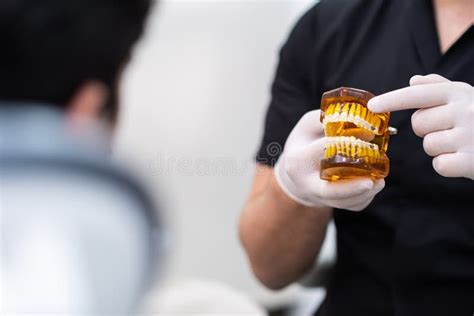 Dentist With Protective Gloves Pointing To Metal Dental Braces