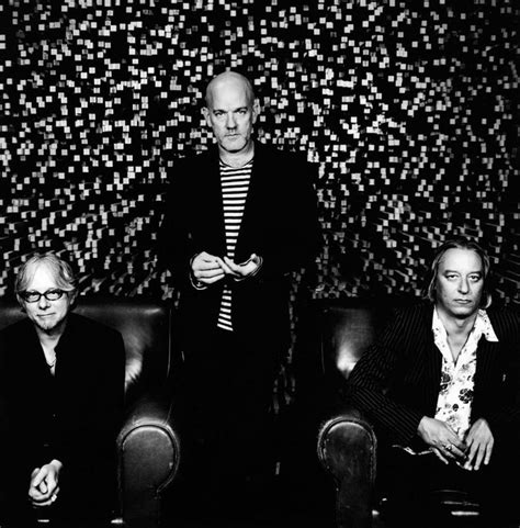 Three Men Sitting On Top Of Leather Chairs In Front Of A Wall With