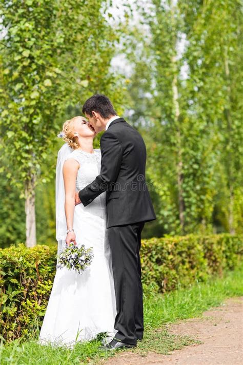 Beautiful Wedding Couple Outdoors They Kiss And Hug Each Other Stock