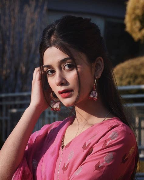 A Woman In A Pink Sari Poses For The Camera With Her Hand On Her Head