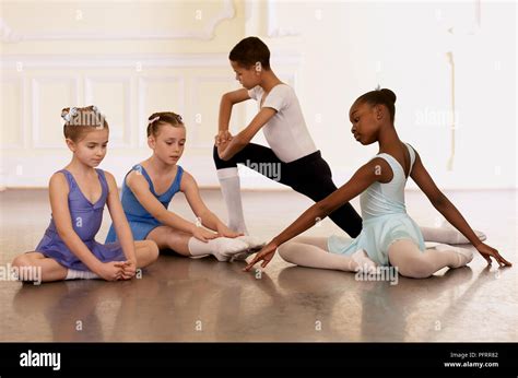 Group Of Young Ballet Dancers Doing Stretching Exercises Stock Photo