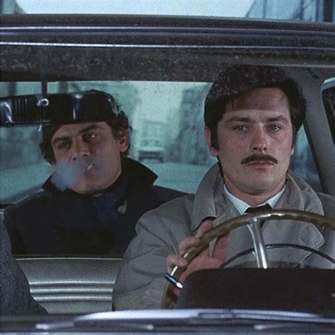 Two Men Sitting In The Driver S Seat Of A Car One With A Moustache