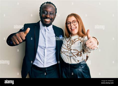 Young Interracial Couple Wearing Business And Elegant Clothes Approving