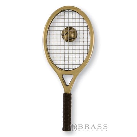 A Gold Tennis Racket With A Golden Ball On It S Backgroung