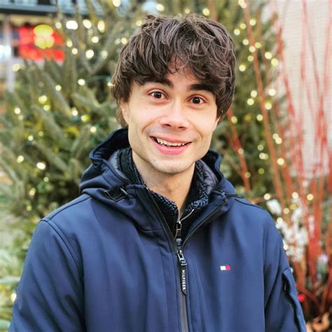 A Man Standing In Front Of A Christmas Tree