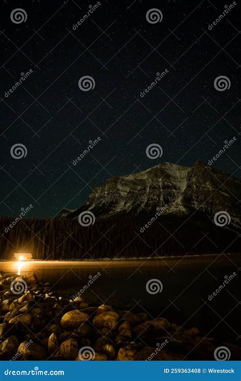 Vertical Shot Of A Cottage On The Shore Of Lake Louise In Banff