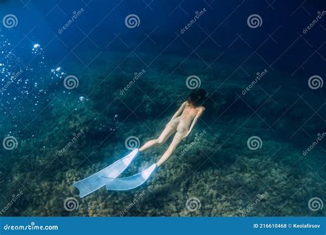 Naked Sporty Woman With Freediving Fins Dive In Ocean Stock Photo