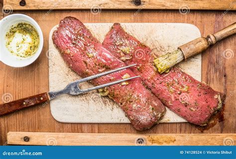 Raw Meat Fillets Marinating With Rub Brush And Fork On Wooden