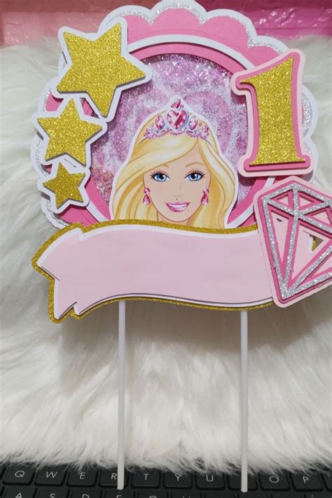 There Is A Cake Topper With A Barbie Doll On It And Stars In The Background