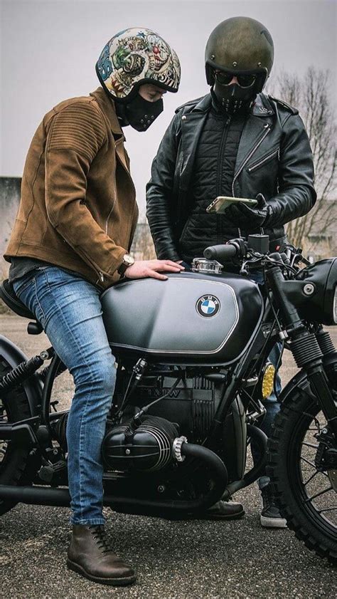 Two Men In Leather Jackets And Helmets Sitting On A Bmw Motorcycle With