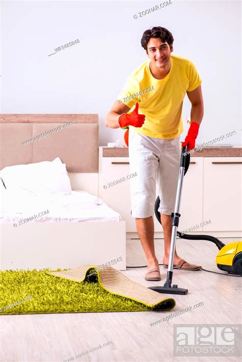 Young Handsome Man Cleaning In The Bedroom Stock Photo Picture And