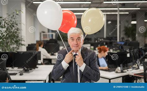 Portrait Of A Cheerful Mature Business Man Holding Balloons In The