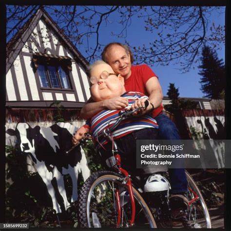 Cartoonist Gary Larson Poses With A Large Doll On A Bicycle In Front